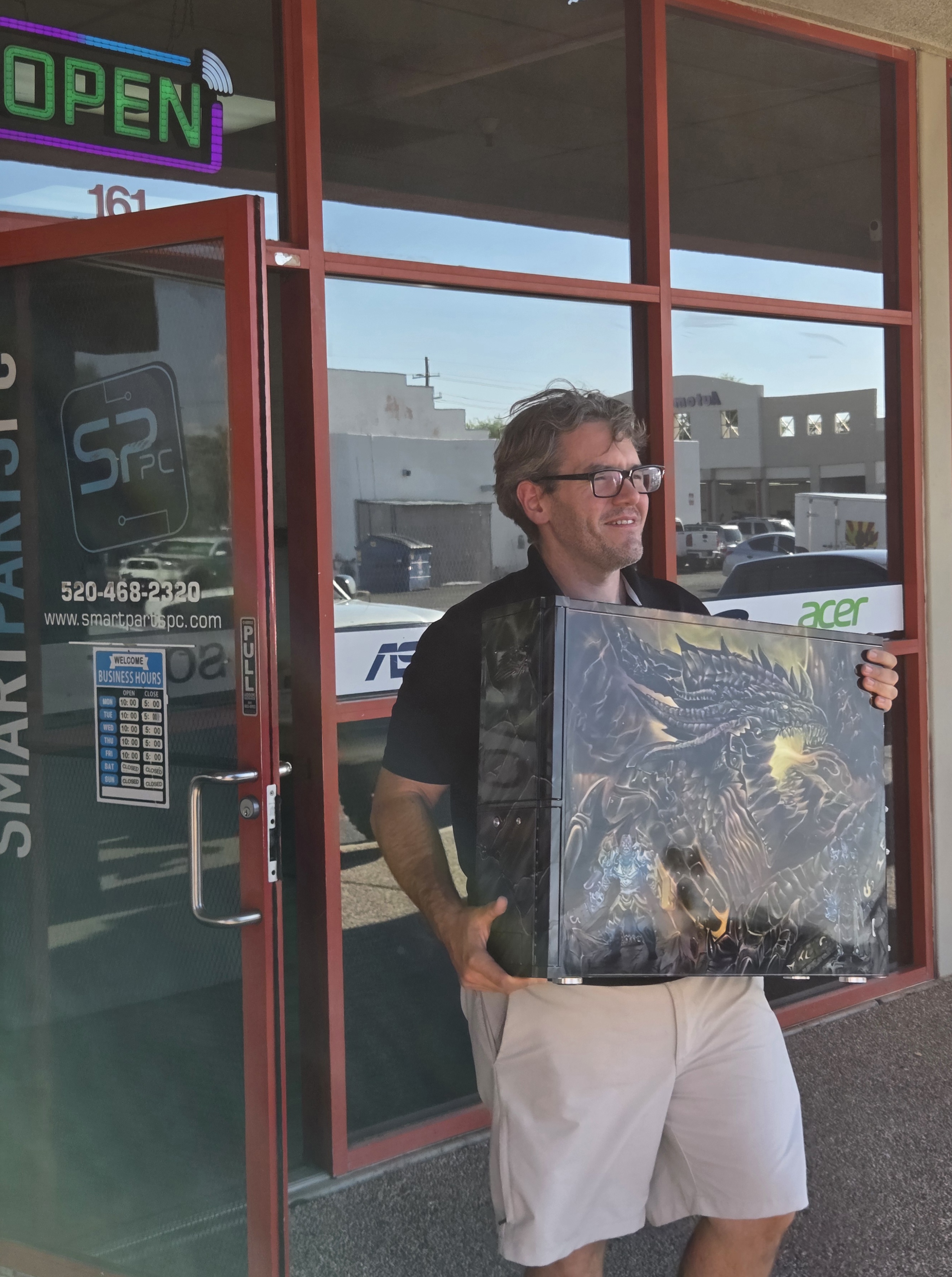 Wesley Schaeppi walking out of Smart Parts PC carrying a custom computer tower.
